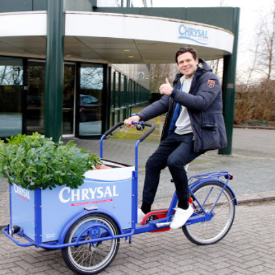 Iemand op een speciale Chrysal-bakfiets in de bedrijfskleuren blauw en wit.